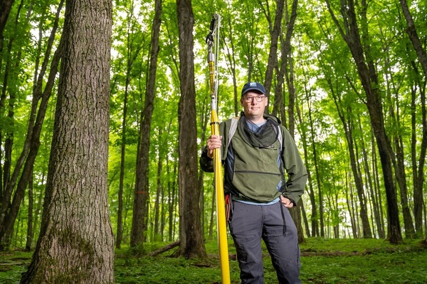 Nate Swenson, a biological sciences professor and the director of UNDERC, holds his pole clipper and ignores the mosquitoes.